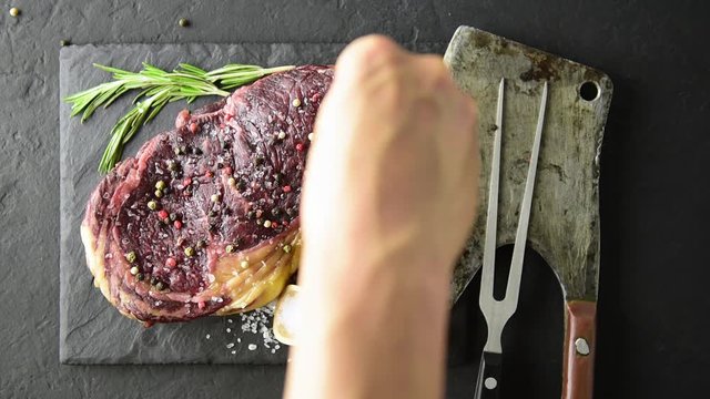 Marbling ribeye steak on black plate. Prime rib beef chop