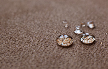 Drops of water on a water resistant fabric of brown color