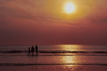 Fototapeta premium Familie im Sonnenuntergang am Strand von Callantsoog in den Niederlanden