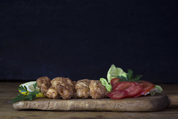Breaded Chicken Meat With Salad And Lemon Resting On a Rustic Wooden Board