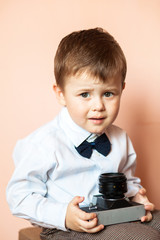 Little boy with aged retro camera. Child with an old camera