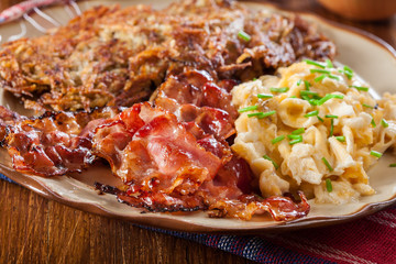 Hash browns. Potato pancakes with crispy fried bacon and scrambled eggs