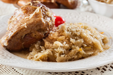 Pork knuckle with fried sauerkraut and tomatoes