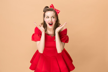 Beautiful young woman with pinup make-up and hairstyle. Studio shot on pastel background