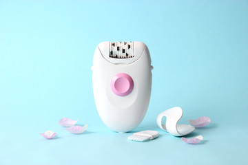 modern epilator and petals on a colored background. minimalism, the top.