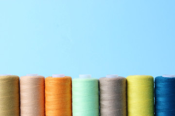 sewing thread of different colors on a colored background.