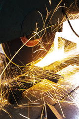 the worker cutting steel with an industrial cutter.