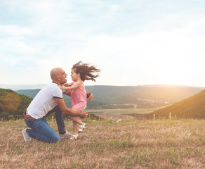 Father holds his pretty daughter and they are hug