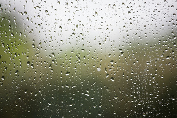 Regentropfen an Fensterscheibe zeigen schlechtes Wetter