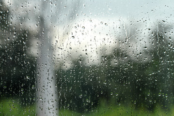 Regentropfen an Fensterscheibe zeigen schlechtes Wetter