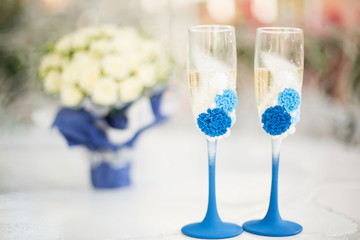 The glasses of the newlyweds. Champagne and a bouquet of the bride. Wedding day. Wedding decorations