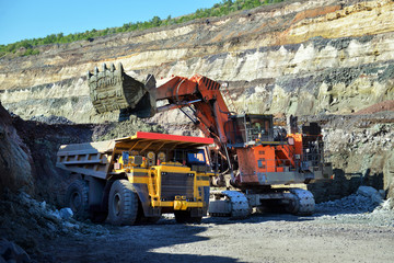 Large quarry dump truck. Loading the rock in the dumper. Loading coal into body work truck