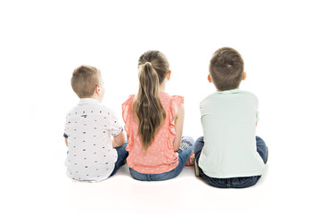 Back view of child group sitting on floor looking at wall
