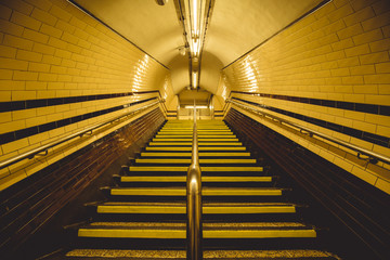 Moody yellow tunnel and staircase on London underground