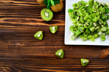 Freshly sliced kiwi fruit with whole kiwis in background.