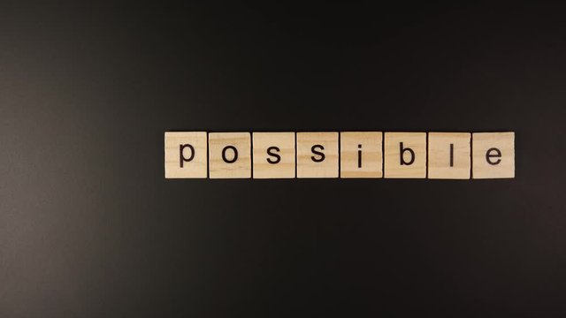 TOP VIEW: From Impossible to Possible - Human hand takes out a few letters