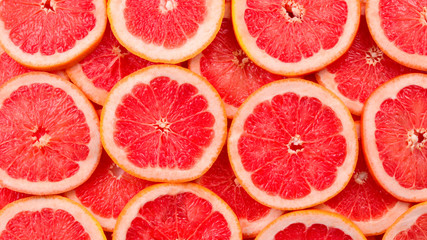 Grapefruit red juicy slices background. top view