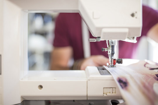 Close-up of man using sewing machine