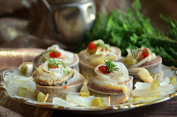 Rollmops with herring with onions on a rustic plate