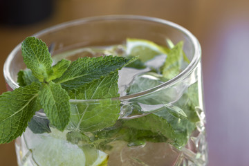 Cocktail with vodka, mint and lemon in glass on the bar