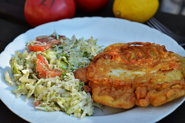 Fish dish. Fried fish with salad on a white plate