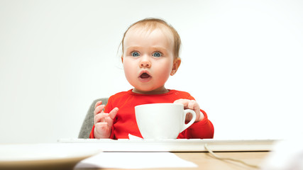 Happy child baby girl toddler sitting with keyboard of computer isolated on a white background