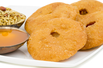 Indian Traditional Sweet Kachori Also Know As Mawa Kachori, Kachauri or Kachodi, Stuffed Kachori With Condensed Milk, Cheese and Dry Fruits And Served With Sugar Syrup isolated on White Background