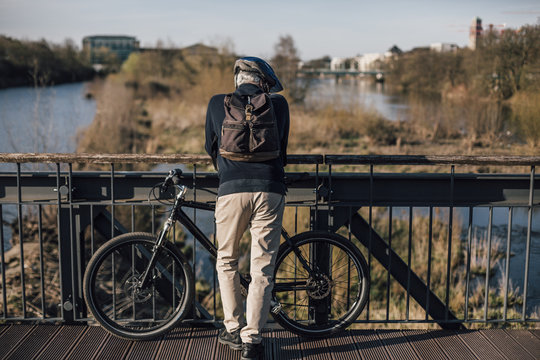 Cyclist standing on bridge