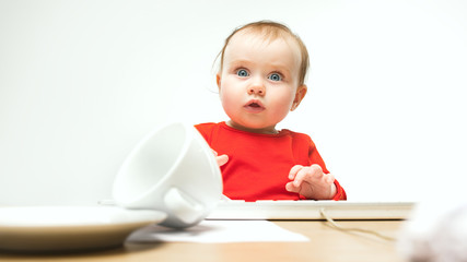 Happy child baby girl toddler sitting with keyboard of computer isolated on a white background