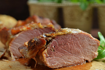 Tasty and juicy roast pork on wooden board