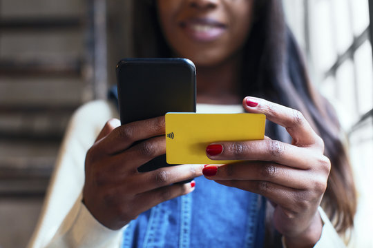 Woman's hands holding cell phone and wifi keycard, close-up