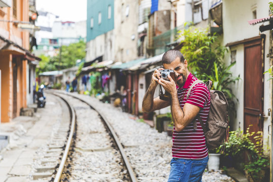 Vietnam, Hanoi, man in the city taking a picture with an old-fashioned camera