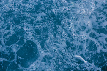 Abstract blue sea water with white foam and bubbles for background, natural summer background, pattern concept