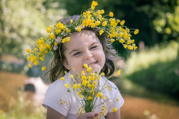 Portrait of a little girl in a wreath of yellow flowers