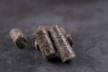 Pellets - new environmentally friendly fuel, close-up on a black background