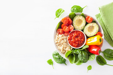 vegan buddha bowl. healthy lunch bowl with avocado, tomato, bell peppers, quinoa and salsa