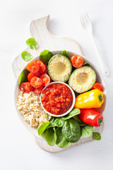 vegan buddha bowl. healthy lunch bowl with avocado, tomato, bell peppers, quinoa and salsa