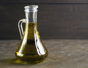 Olive oil in a jug on a dark background.