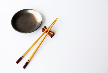 chopsticks and Ceramic plate on white background.Flat lay