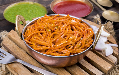 Spicy Fried Vegetable Veg Chow Mein Served With Green And Red Chutney Also Know as Noodles or Hakka Noodles is a Popular Oriental Dish With Noodles And Vegetables on Wooden Table