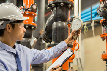 Engineer checking Condenser Water pump and pressure gauge , chiller water pump with pressure gauge.