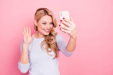 Portrait of positive friendly girl having rest relax making video call with friend parents lover gesturing palm hi sign isolated on pink background