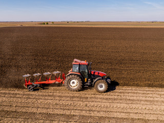 Aerial shot of a farmer plowing stubble field