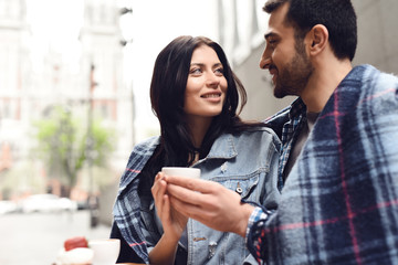 Guy with a girl holding a cup of coffee.