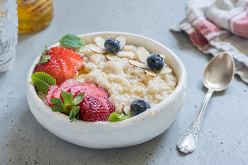 Steel cut oatmeal porridge with strawberry and blueberry for breakfast