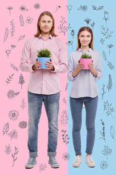 Cheerful gardeners. Positive professional gardeners smiling and standing with lovely flower pots in their hands while being at work