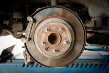 Rusted disc brake and caliper on car with space for text input.