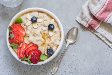 Steel cut oatmeal porridge with strawberry and blueberry for breakfast