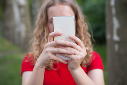 Girl taking a selfie with a mobile phone or writing something.