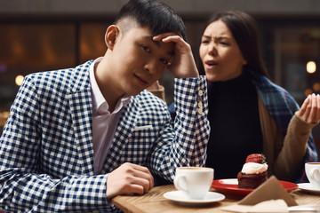 Couple screeches in coffee shop at table.